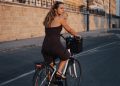 a woman riding a bike down a street