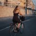 a woman riding a bike down a street